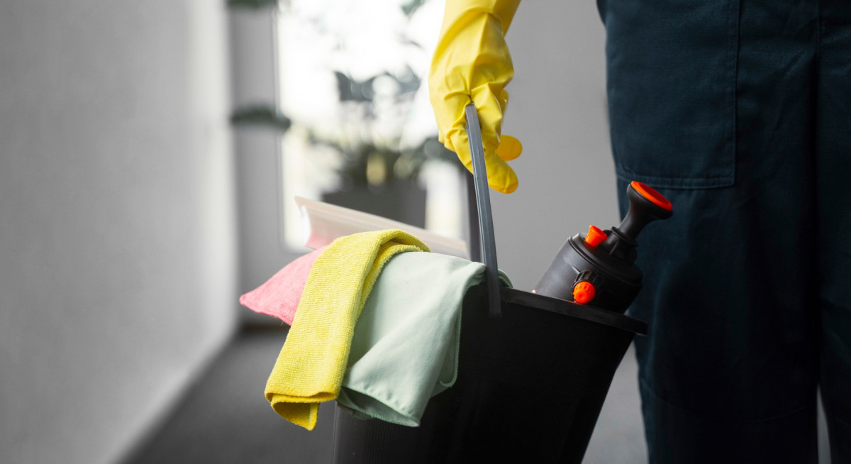 Reinigungskraft mit Reinigungsutensilien und professioneller Reinigungsausrüstung